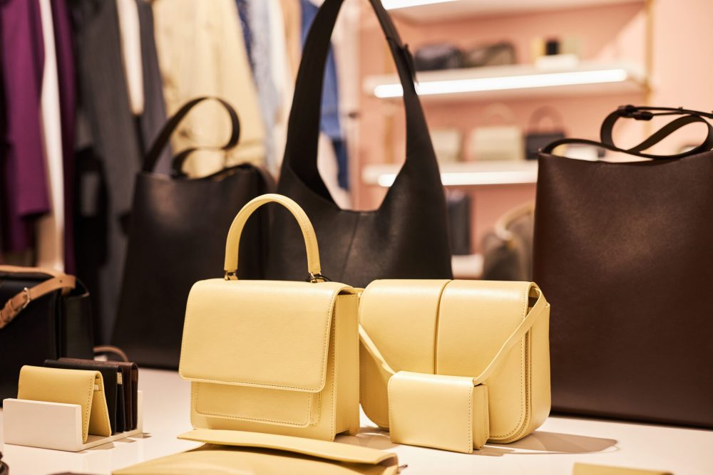 Closeup background image of designer bags and accessories in clothing boutique interior, copy space